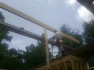 Carpenter setting a ridge beam over a new addition frame — Ice Dam Removal by Roofing Brothers in Glade Valley