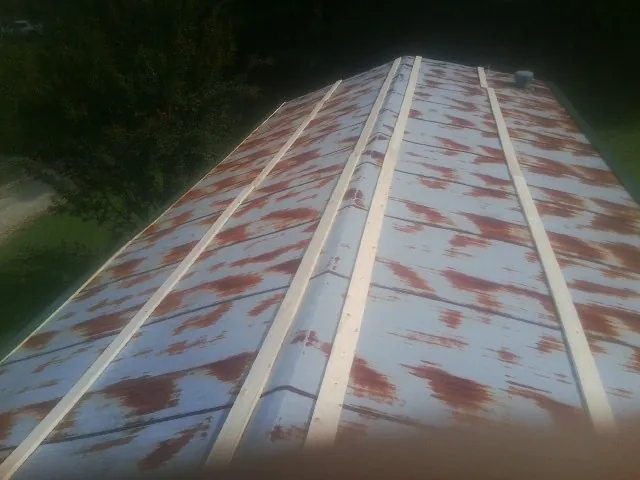 Rusted metal roof panels with new wood purlins before replacement — Storm Damage Roof Repair in Glade Valley by Roofing Brothers