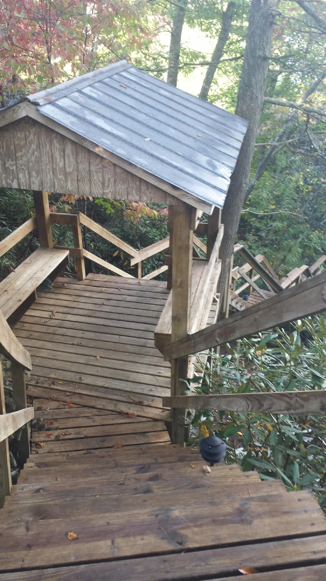 Metal roofed shelter over wooden steps on a wooded walkway — Skylight Repair & Installation work by our crew in Glade Valley