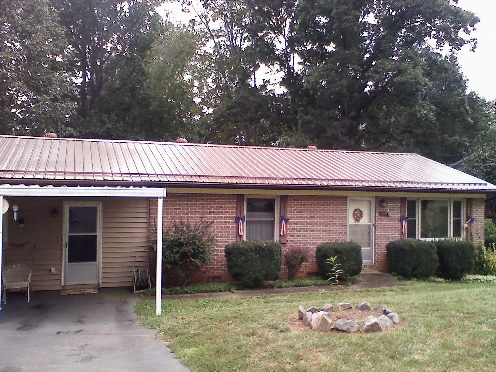 Bronze metal roof and carport on a brick ranch home — Roof Repair work by our crew in Glade Valley
